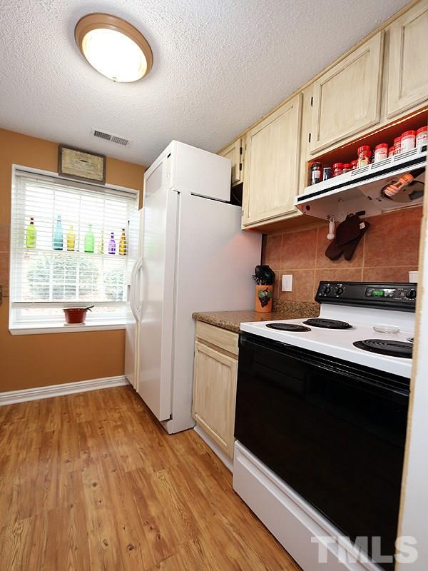 7766 Sandra Lane Raleigh, NC 27615 - Photo 8 of 14 a kitchen with stainless steel appliances granite countertop a refrigerator and a stove