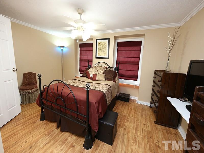 7766 Sandra Lane Raleigh, NC 27615 - Photo 10 of 14 a bedroom with bed and wooden floor