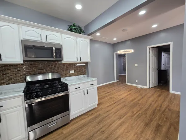 a kitchen with stainless steel appliances kitchen island granite countertop a stove a sink and a microwave