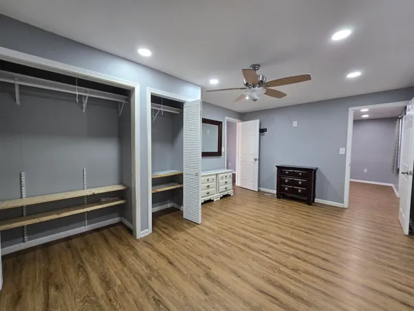 wooden floor in an empty room with a fireplace and a window
