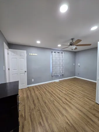 a view of empty room with wooden floor