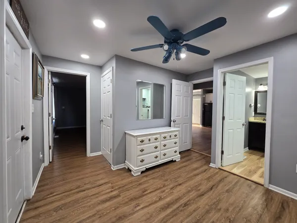 a view of a hallway with wooden floor and cabinet