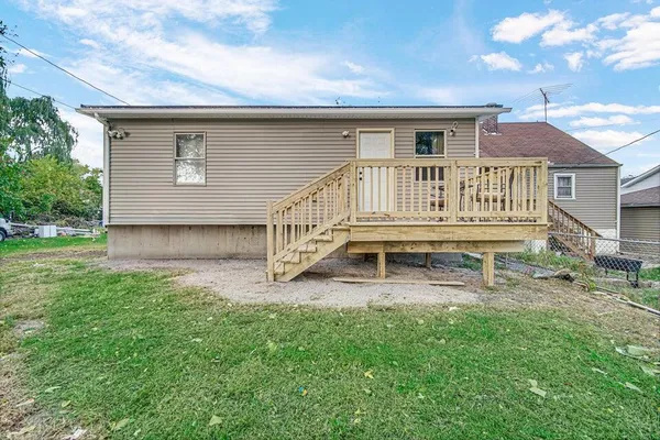front view of house with a yard and deck