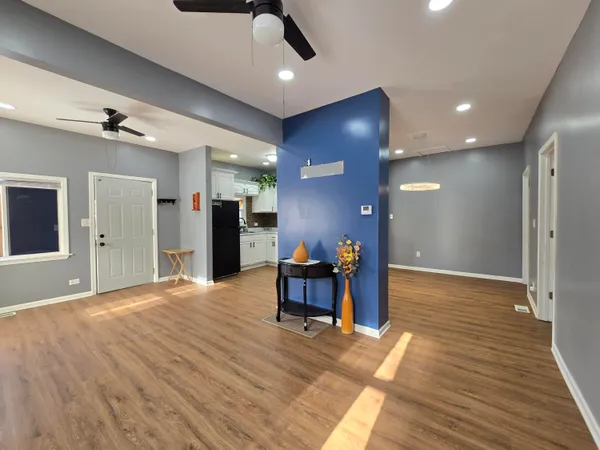 a view of a livingroom with furniture wooden floor and a ceiling fan