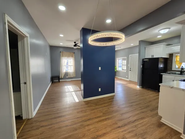 a view of a hallway with wooden floor and staircase