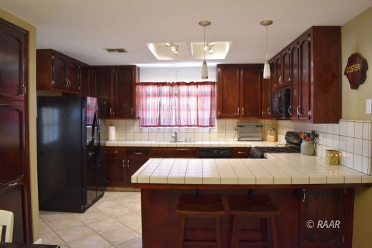 321 East Wilson Avenue Ridgecrest, CA 93555 - Photo 7 of 16 a kitchen with a sink a refrigerator and cabinets