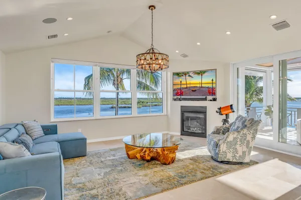 a kitchen with a dining table cabinets stainless steel appliances and a chandelier
