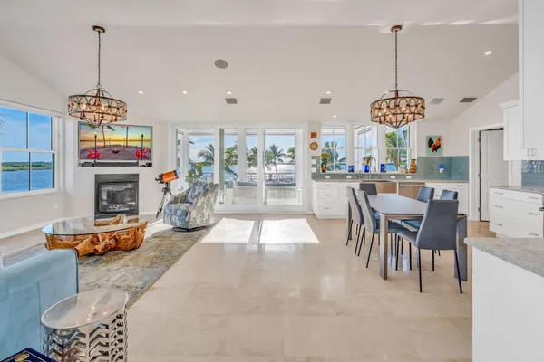 a kitchen with stainless steel appliances granite countertop a stove a refrigerator a oven a sink with a dining table and chairs