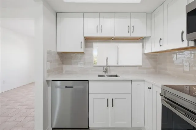 a kitchen with cabinets appliances and a sink