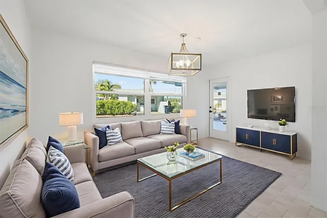 a living room with furniture a flat screen tv and a large window