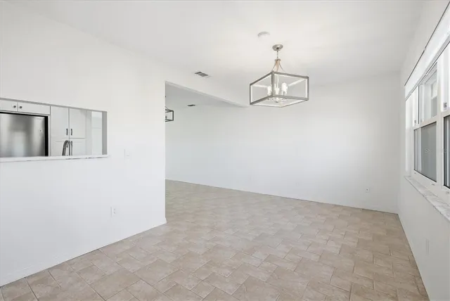 an empty room with windows and cabinet
