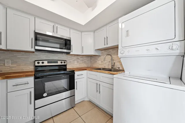 a kitchen with granite countertop white cabinets stainless steel appliances and a sink
