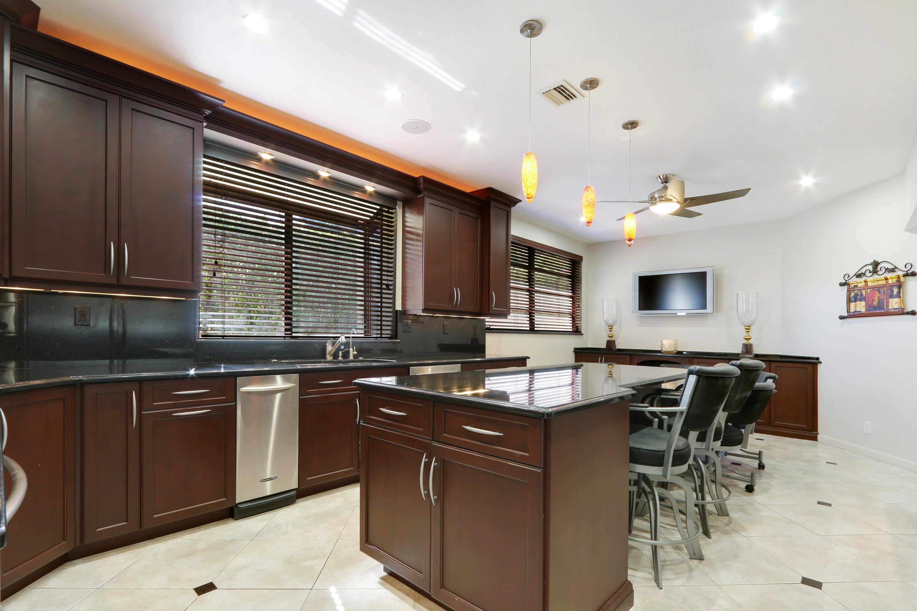 1583 Southwest 6th Terrace Boca Raton, FL 33486 - Photo 8 of 36 a kitchen with stainless steel appliances granite countertop wooden cabinets a dining table and chairs