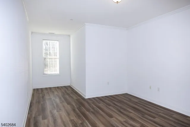 a view of a room with wooden floor and window