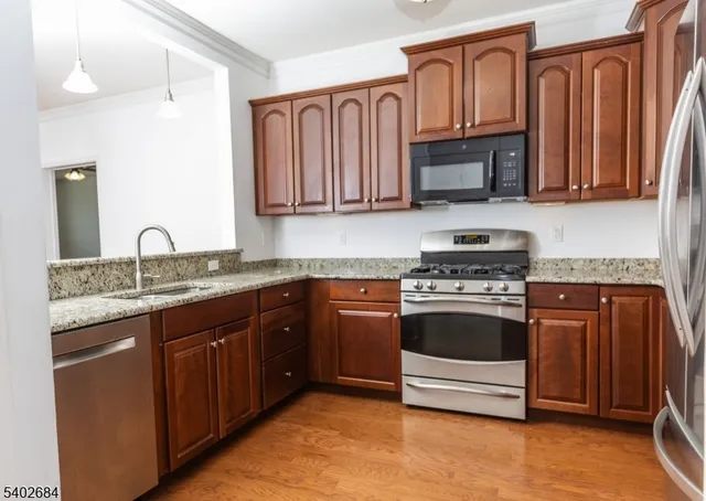 a kitchen with stainless steel appliances granite countertop a sink stove and microwave
