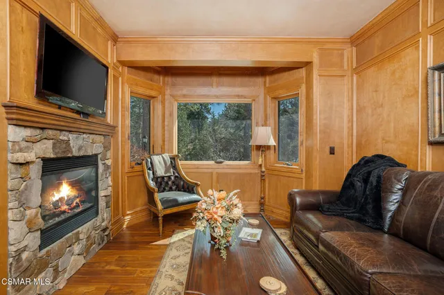 a bedroom with a bed a fireplace and a flat tv screen