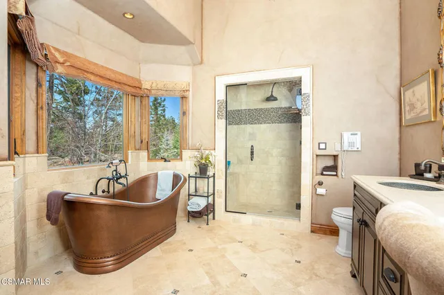 a bathroom with a toilet a sink a mirror and shower