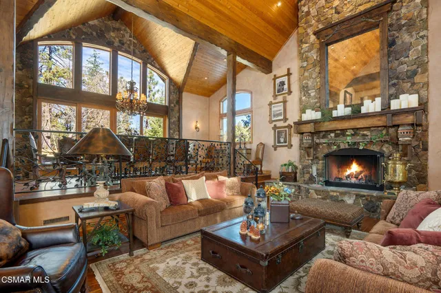 a living room with fireplace furniture and a floor to ceiling window