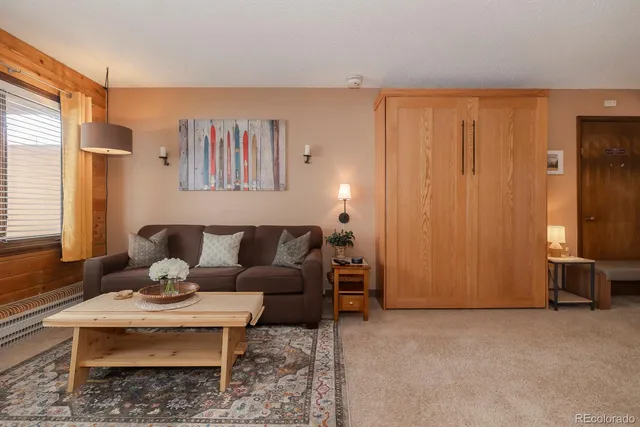 a living room with furniture wooden floor and a window