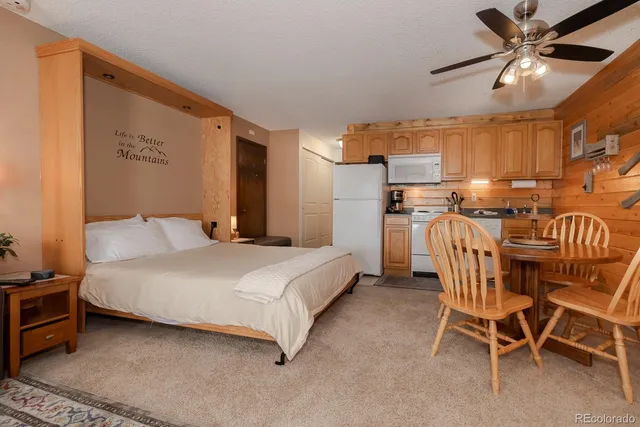 a spacious bedroom with a bed and a chandelier