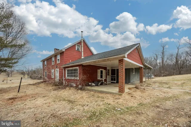 a front view of house with yard and trees in the background
