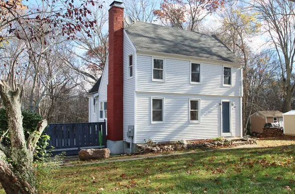 a view of a house with backyard and trees