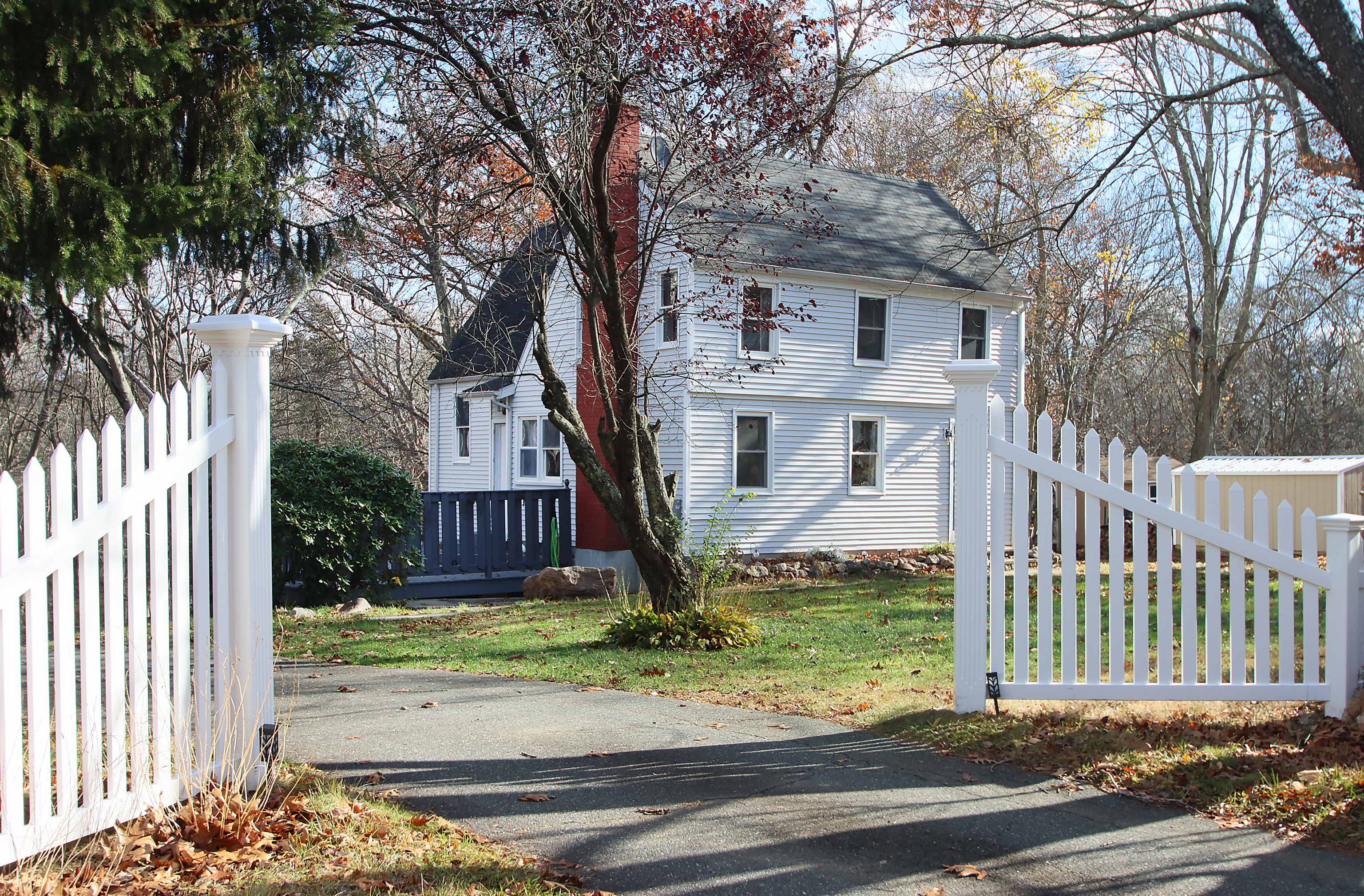 20 Carriage Drive Clinton, CT 06413 - Photo 28 of 31 a front view of a house with a yard tree and wooden fence