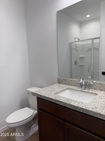 a bathroom with a granite countertop toilet sink and mirror
