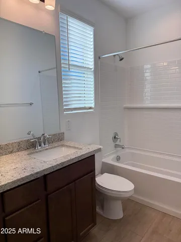 a bathroom with a granite countertop sink toilet a large mirror and shower