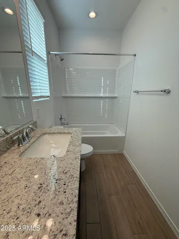 a bathroom with a granite countertop sink a toilet and bathtub