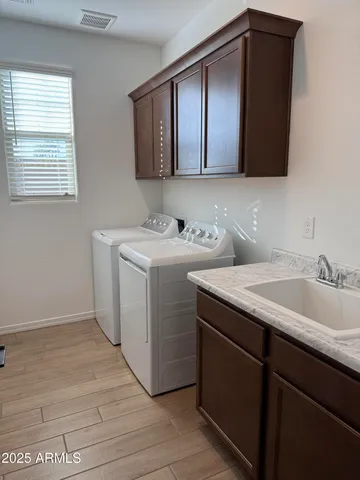 a utility room with sink dryer and washer