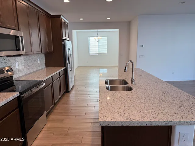 a kitchen with stainless steel appliances granite countertop a sink stove and refrigerator