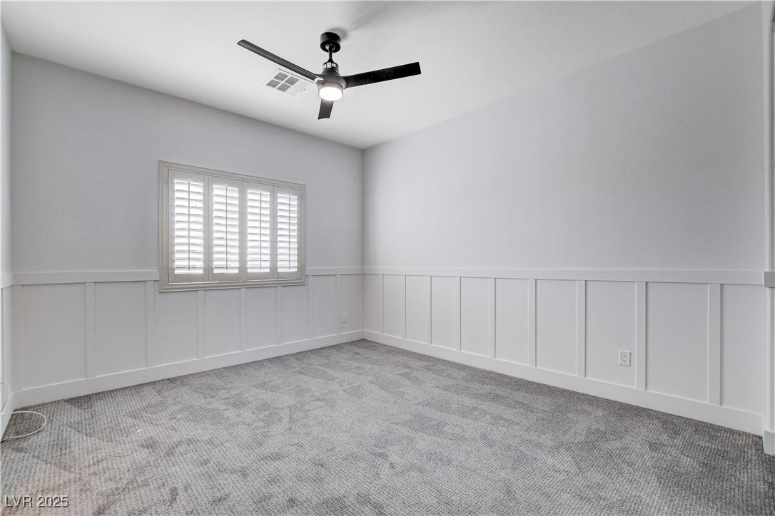 5148 Villa Vecchio Court Las Vegas, NV 89141 - Photo 56 of 71 Spare room with visible vents, a ceiling fan, a wainscoted wall, and carpet floors