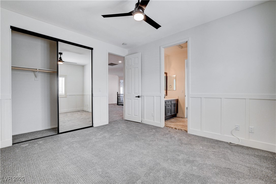 5148 Villa Vecchio Court Las Vegas, NV 89141 - Photo 57 of 71 Unfurnished bedroom featuring a wainscoted wall, a closet, carpet floors, and ceiling fan