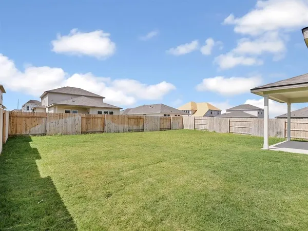 a view of a big house with a big yard and large trees