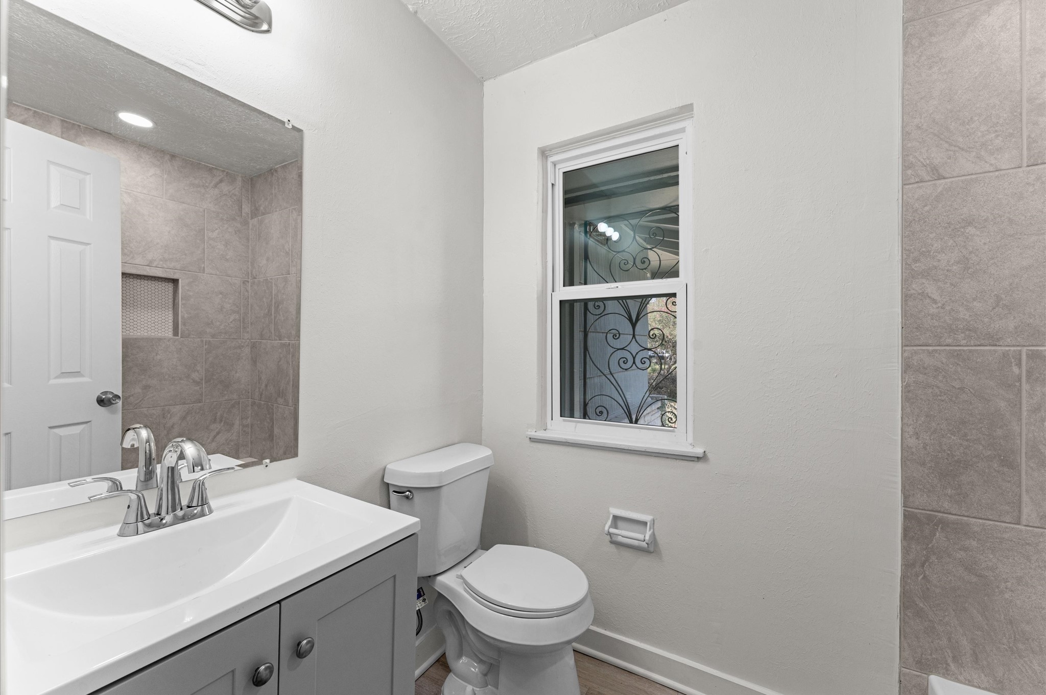 6515 Beekman Road Houston, TX 77021 - Photo 15 of 30 a bathroom with a toilet a sink a mirror and vanity