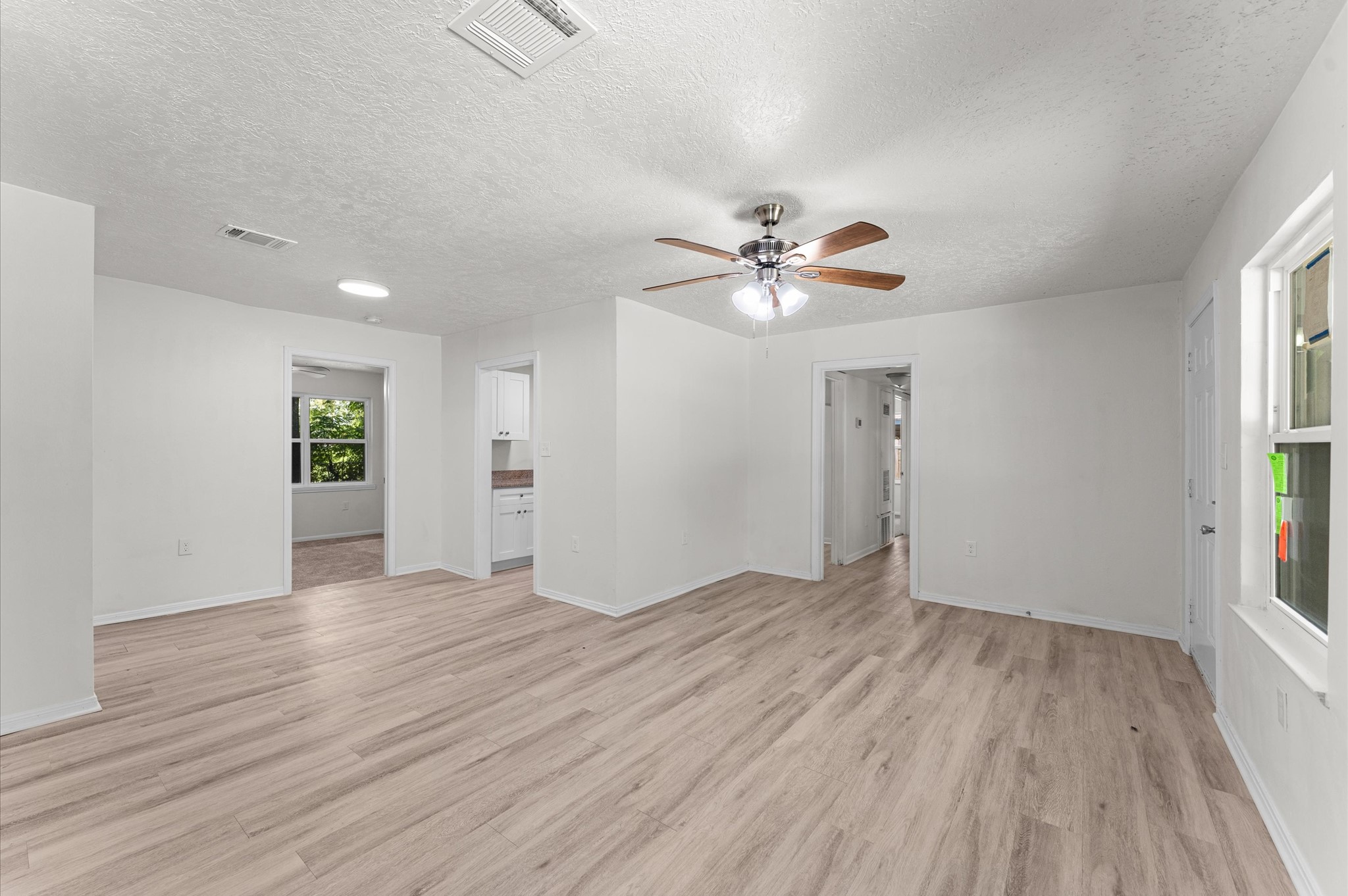 6515 Beekman Road Houston, TX 77021 - Photo 9 of 30 an empty room with wooden floor chandelier fan and windows