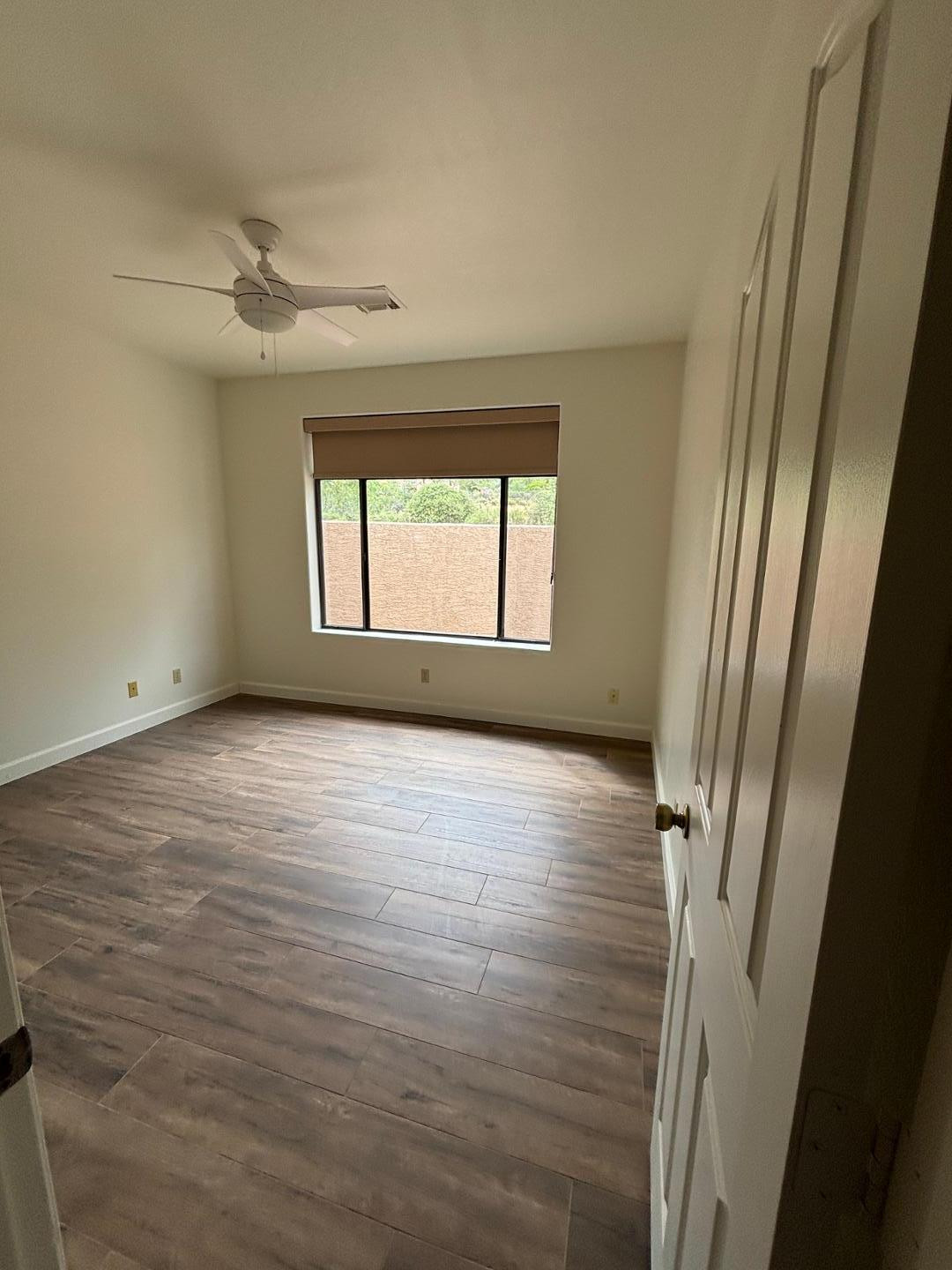 43003 North Old Mine Road Scottsdale, AZ 85262 - Photo 19 of 33 an empty room with wooden floor and windows