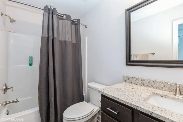 a bathroom with a granite countertop sink toilet and shower