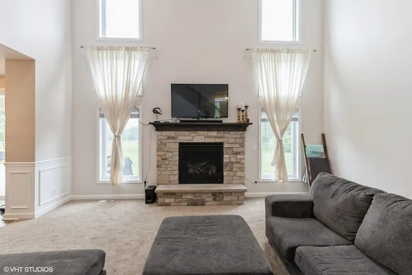 a living room with furniture a flat screen tv and a fireplace