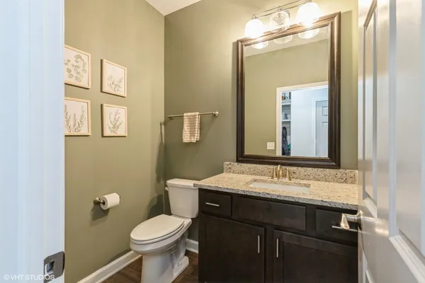 a bathroom with a sink vanity mirror and toilet