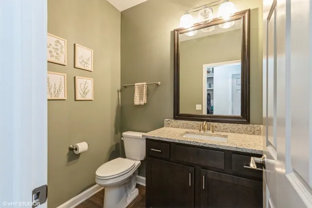 a bathroom with a sink vanity mirror and toilet