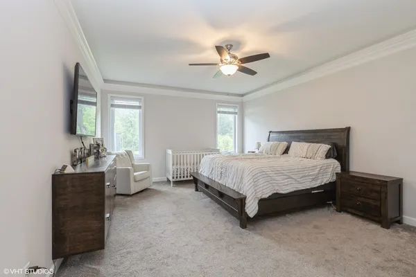 a spacious bedroom with a bed and a chandelier