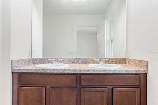 a bathroom with a granite countertop sink and white cabinets