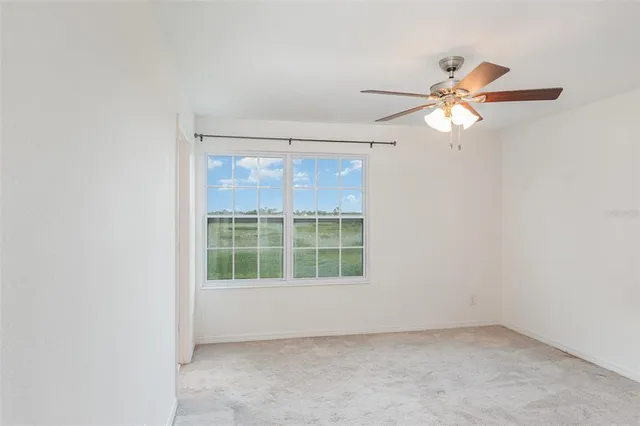 an empty room with chandelier fan