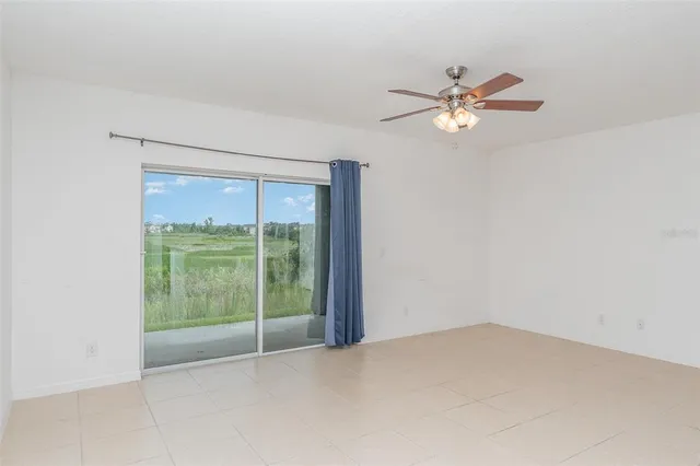 a view of a room with a ceiling fan and a large window