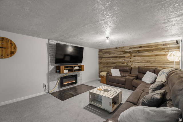 961 33rd Street Ogden, UT 84403 - Photo 21 of 39 Recreational area featuring an accent wall with a mounted electric fireplace, a wall-mounted media console, and a wood-finish plank accent wall