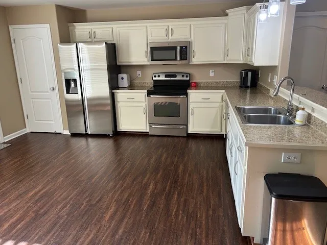 a kitchen with stainless steel appliances a refrigerator microwave and sink
