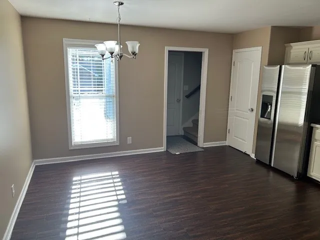 a view of a livingroom with wooden floor and a window