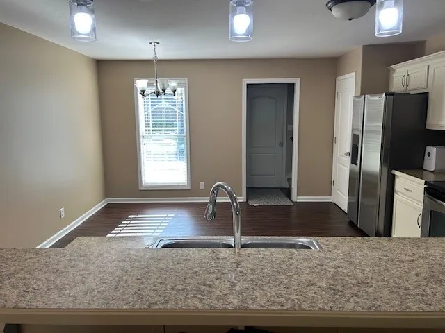 a kitchen with granite countertop a sink and a refrigerator